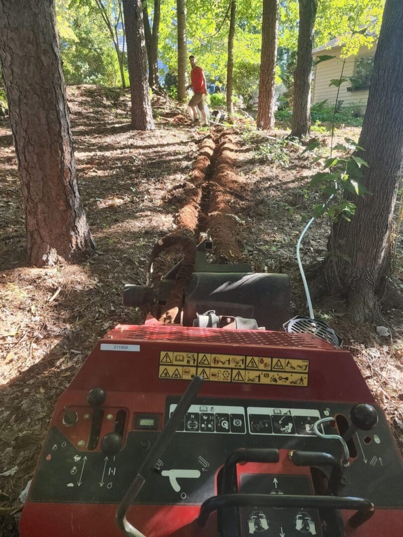 A red tractor is parked in the woods