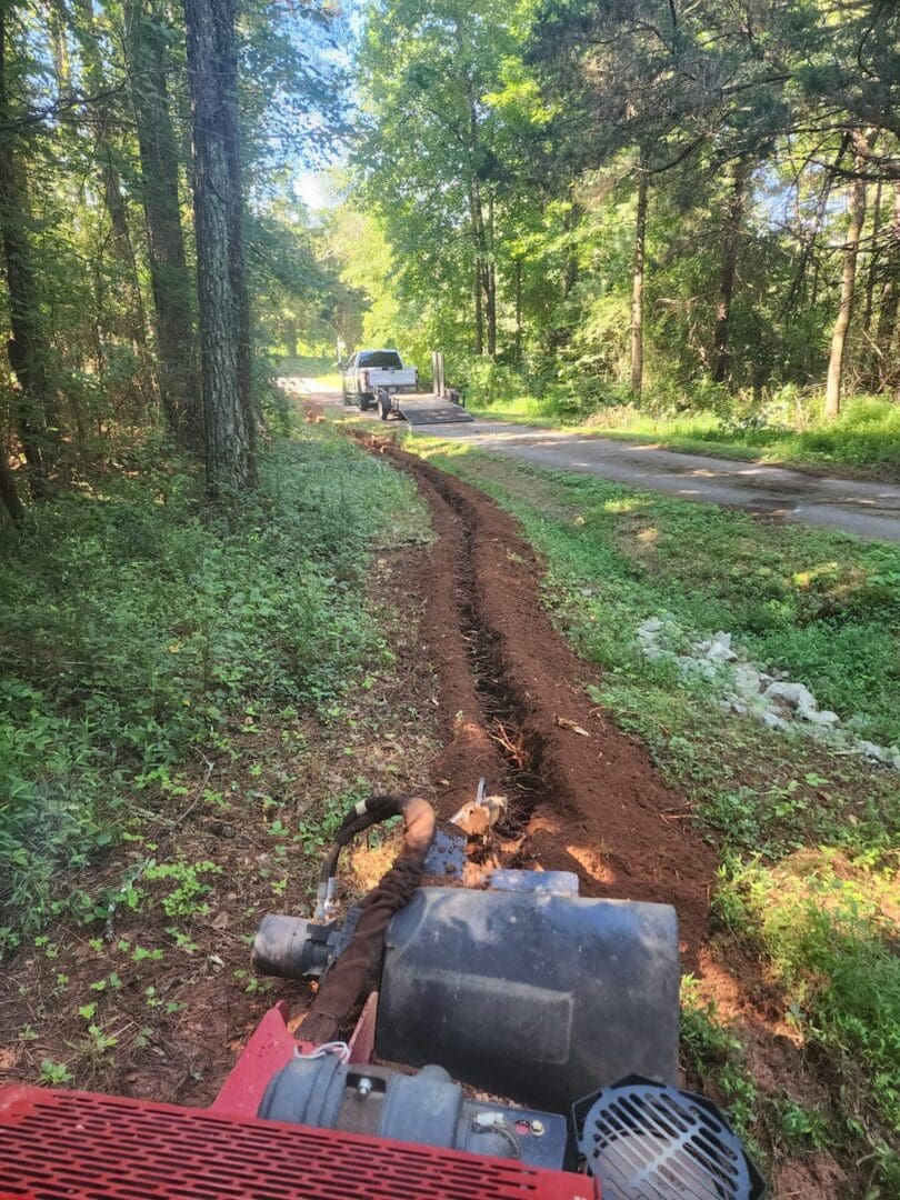 A truck is driving down the road in the woods.