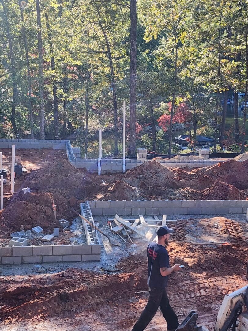 A man standing in front of some dirt and trees