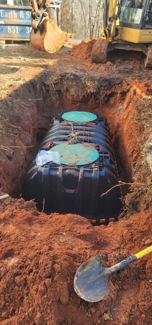 A black and green tank in the middle of a hole.